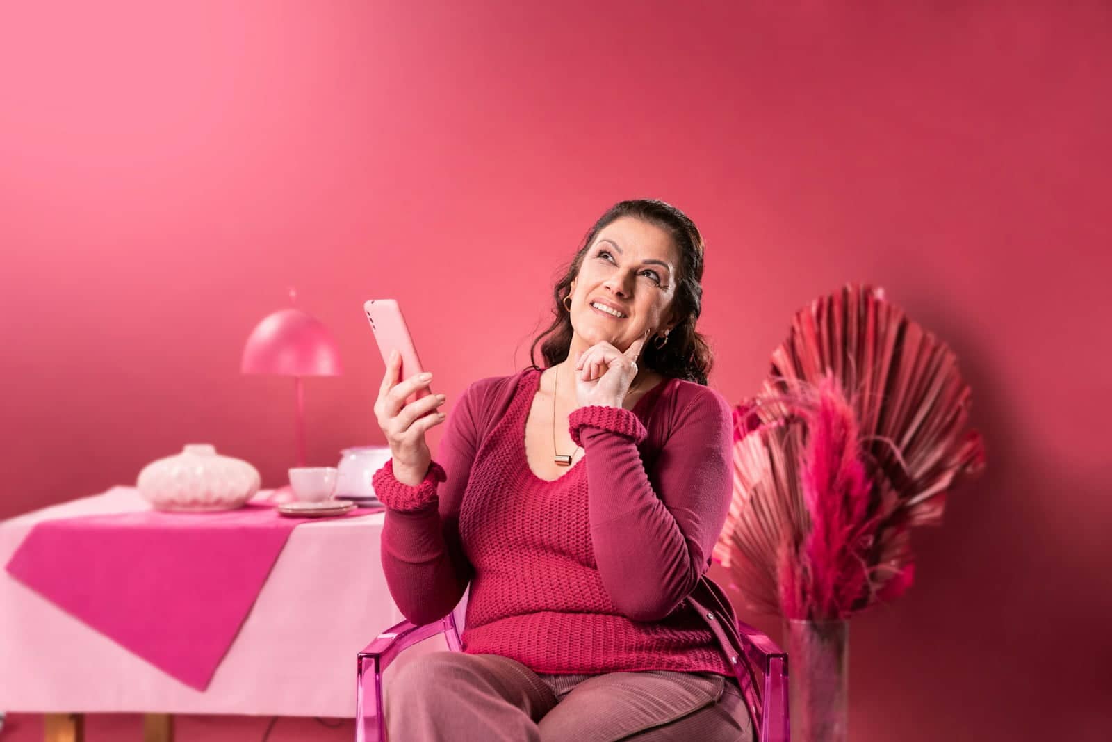 a woman sitting in a chair holding a cell phone